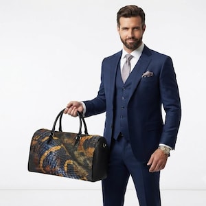 Puede incluir: Un bolso de viaje con un patrón texturizado de piel de serpiente multicolor en tonos marrón, dorado y azul, con asas y paneles laterales de cuero negro. El bolso tiene una forma cilíndrica y es sostenido por una persona con un traje azul marino.