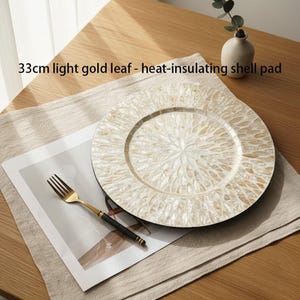 May include: A 33cm light gold leaf heat-insulating shell pad featuring a circular design with a radial pattern of iridescent shell fragments. The pad has a textured surface with a shimmering finish and a defined border, presented as a flat round mat.
