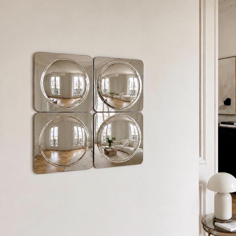 May include: A set of four square wall mirrors arranged in a two-by-two grid. Each mirror features a central circular convex surface that creates a wide-angle reflection of the room, framed by a smooth, flat, silver-toned metallic square border.