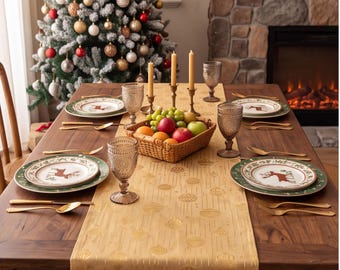 Op de afbeelding: Een houten eettafel gedekt voor een feestelijke maaltijd met een gouden tafelloper met ornamentpatronen, witte borden met rendiermotieven, groene onderborden, gouden bestek, amberkleurige glazen en een mand met vers fruit.