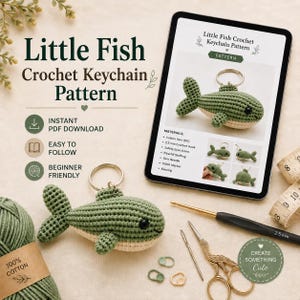 May include: A crochet pattern for a little fish keychain displayed on a tablet screen, accompanied by a finished green and cream crocheted fish keychain, a 2.5 mm crochet hook, scissors, stitch markers, and a ball of 100% cotton yarn.