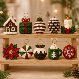 May include: A collection of ten crocheted Christmas ornaments with gold-tone metal rings. The set includes a gingerbread house, a green gift box, a striped ball, a pinecone, a candle, a poinsettia, a peppermint, a pudding, a mug, and a snowflake.