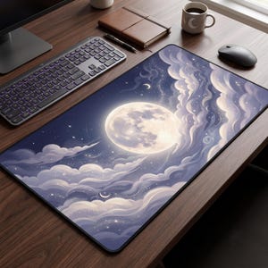 Op de afbeelding: Een rechthoekige bureaumat met een illustratie van een nachtelijke hemel met een grote, gloeiende volle maan, wervelende lichtpaarse en witte wolken en verspreide sterren. De mat heeft een zwarte rand op een donkerhouten bureau.