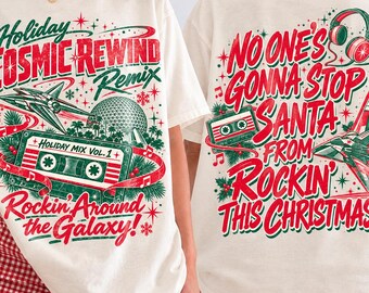 May include: An off-white t-shirt featuring a graphic print on the front and back. The front displays a cassette tape, a spaceship, and the text Holiday Cosmic Rewind Remix Rockin Around the Galaxy. The back features headphones, a cassette, a spaceship, and the text No One's Gonna Stop Santa From Rockin This Christmas.