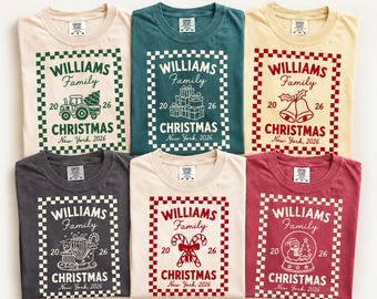 May include: Six short-sleeve t-shirts in various colors, each featuring a checkered border and the text "WILLIAMS Family 20 26 CHRISTMAS New York, 2026" with unique holiday graphics including a tractor, gifts, bells, a sleigh, candy canes, and a snow globe.