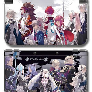 May include: A handheld gaming console featuring two distinct panels decorated with anime-style character illustrations. The top panel displays a group of figures against a light sky, while the bottom panel shows characters on a dark background with the text Fire Emblem.