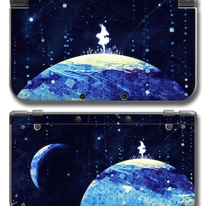 May include: A handheld gaming console featuring a dark blue space-themed skin. The design displays a silhouette of a figure standing on a glowing blue planet against a starry background with geometric patterns and a smaller crescent planet visible.