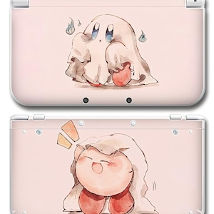 May include: A light pink handheld gaming console featuring a watercolor-style illustration of the character Kirby wearing a white ghost sheet. The top panel shows Kirby as a ghost, while the bottom panel shows Kirby smiling under the sheet.