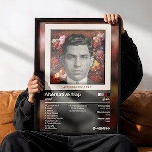以下が含まれることがあります： LUCKIのアルバム「Alternative Trap」のジャケットが印刷された額入りポスター。花を背景にした男性のポートレート、1から13までのトラックリスト、2013年2月25日のリリース日、45分19秒のアルバムの長さ、レコードレーベル名が記載されています。