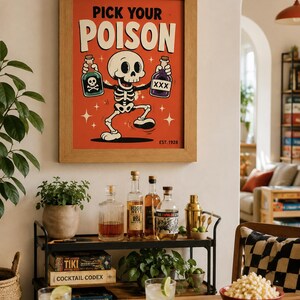 May include: A framed wall art print featuring a cartoon skeleton on a red background with the text PICK YOUR POISON and EST. 1928. The skeleton holds a green bottle with a skull and crossbones and a purple bottle labeled XXX, surrounded by stars.