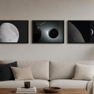 May include: A set of three rectangular wall art prints in black frames, each featuring a high-contrast black and white photograph of celestial bodies, including a detailed lunar surface, a solar eclipse, and a crescent moon against a dark sky.