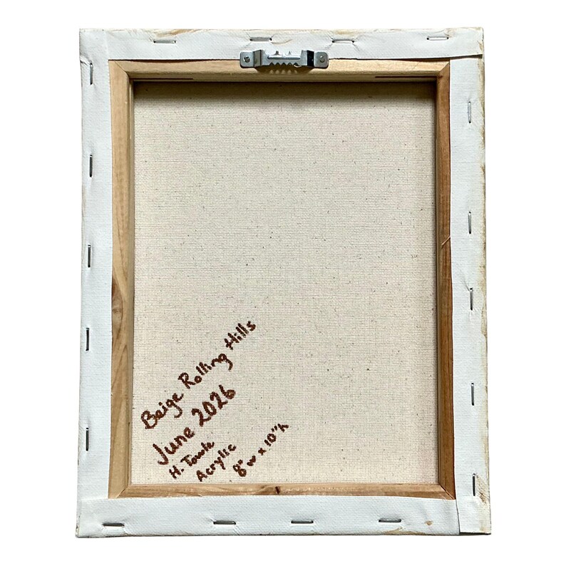 Op de afbeelding: De achterkant van een rechthoekig canvas op een houten frame met een metalen zaagtandhanger. Handgeschreven tekst in bruine inkt luidt: Beige Rolling Hills, June 2026, H. Towle, Acrylic, 20,32 cm breed bij 25,4 cm hoog.