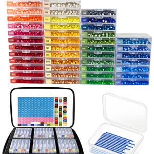 May include: A collection of clear plastic storage containers filled with small, multi-colored round rhinestones, organized by numerical color codes. Includes a black carrying case with foam inserts and a single open container with blue rhinestones.