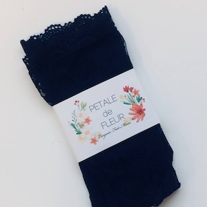 May include: Black lace lingerie with a white tag that reads "PETALE de FLEUR Lingerie Fait-Main".