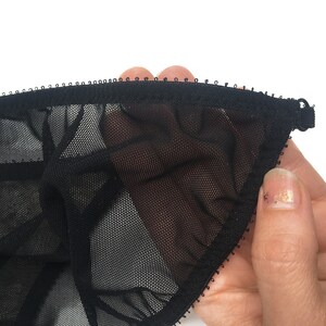 K&ouml;nnte beinhalten: Schwarze Netz-Dessous mit schwarzem elastischem Besatz. Das Netz ist fein und zart.