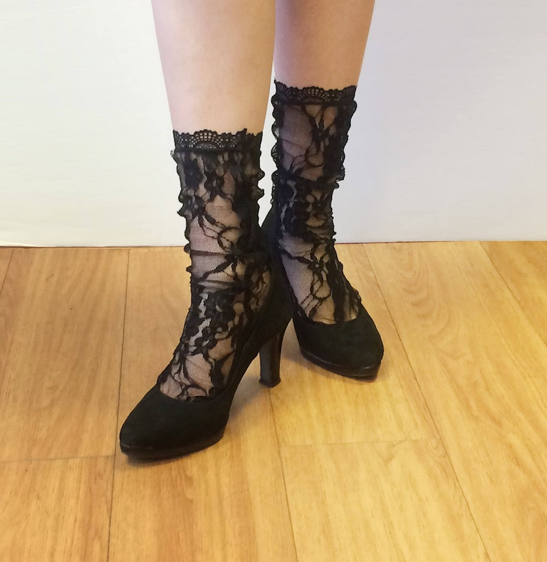 May include: A pair of black lace socks with floral patterns worn with black heels.