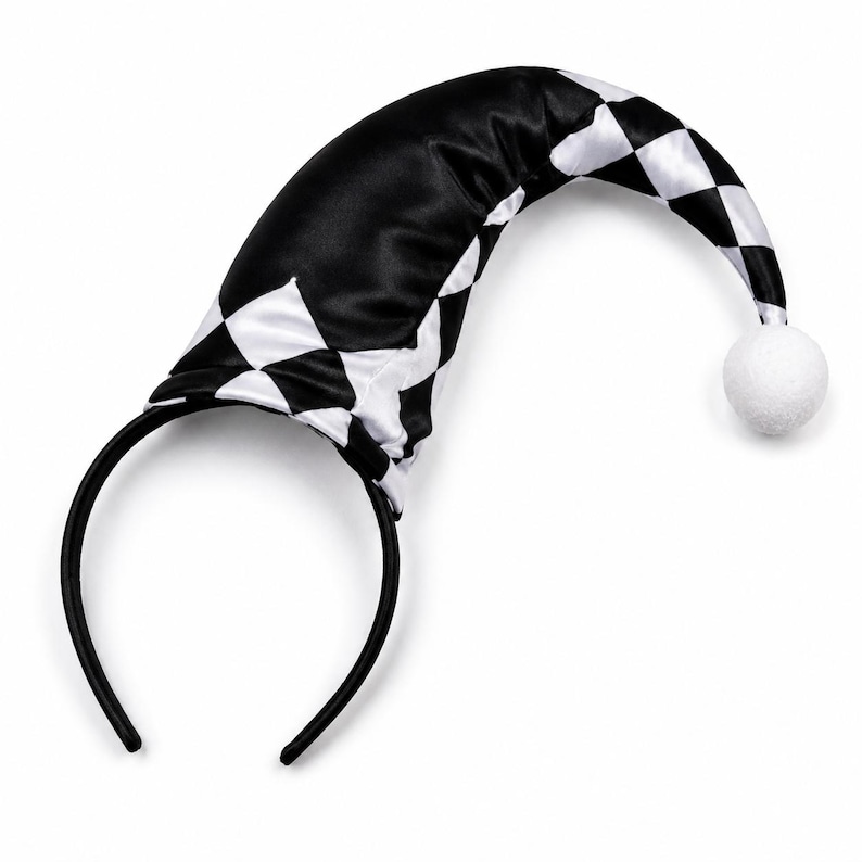 Puede incluir: Una diadema negra con un accesorio de sombrero curvo y puntiagudo. El sombrero est&aacute; hecho de una tela satinada con un patr&oacute;n de cuadros de diamantes en blanco y negro y termina con un peque&ntilde;o pomp&oacute;n blanco y redondo en la punta.