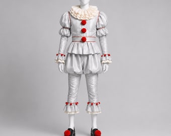 Puede incluir: Un disfraz de payaso gris plateado con cuello de volantes, mangas abullonadas y cintura con volante. El conjunto incluye tres grandes pompones rojos en la parte delantera, pompones rojos a juego en puños y bajos, y zapatos negros con pompones.