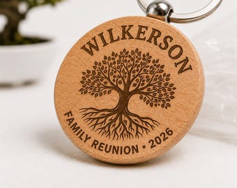 May include: A round wooden keychain featuring a laser-engraved tree design with roots. The text "WILKERSON" is arched at the top, while "FAMILY REUNION" and "2026" are engraved at the bottom. It includes a silver-toned metal split ring attachment.
