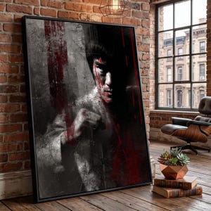 Puede incluir: Una pieza de arte mural rectangular enmarcada que presenta un retrato en blanco y negro de alto contraste de un artista marcial en posición de combate, acentuado con rayas verticales de pintura roja intensa en el rostro y el torso, en un marco negro.