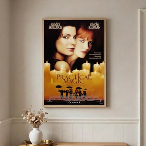 May include: A rectangular movie poster for Practical Magic featuring Sandra Bullock and Nicole Kidman. The poster displays a warm, golden-toned background filled with glowing candles, silhouettes of figures with umbrellas, and the film title.