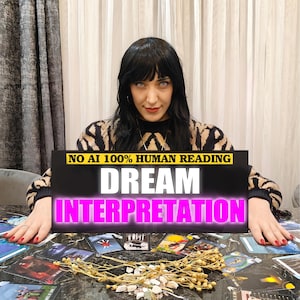 May include: A black rectangular sign with the yellow text NO AI 100% HUMAN READING, white text DREAM, and magenta text INTERPRETATION. The sign is positioned over a table covered with various tarot cards and a cluster of dried plant stems and small stones.