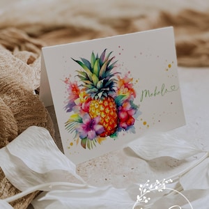 May include: A white greeting card featuring a watercolor pineapple design surrounded by colorful flowers. The word "Mahalo" is written in green script. The Ann Green Cards logo is at the bottom.
