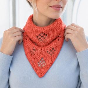 May include: A bright coral orange knitted neckerchief featuring a triangular shape and a delicate lace-like diamond pattern. The accessory is crafted with a textured yarn and sits around the neck, showcasing an openwork design throughout the fabric.