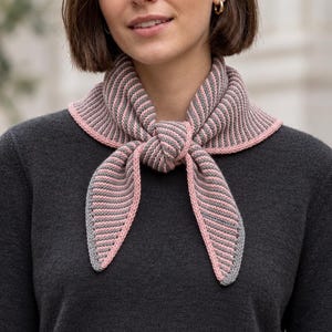 May include: A triangular knit scarf featuring a ribbed texture with alternating grey and soft pink stripes. The scarf is tied in a simple knot at the front, showcasing a solid pink border along the edges of the fabric. The design is symmetrical.