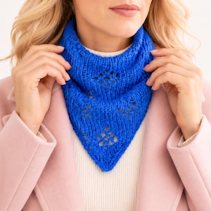 May include: A vibrant royal blue knitted neck warmer featuring a delicate openwork diamond pattern. The accessory has a triangular front drape and a ribbed texture, crafted with a soft yarn finish that sits comfortably around the neck area.