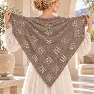 May include: A triangular knit shawl in a muted taupe colour featuring a repeating diamond-shaped openwork pattern. The shawl is crafted with a textured yarn and displays a symmetrical design with a pointed bottom edge and a wide top border.