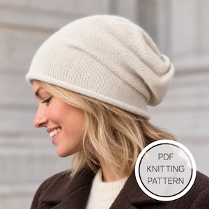 May include: A cream-coloured knit beanie with a soft, slouchy silhouette and a rolled edge. The beanie features a fine, uniform stitch pattern. A circular white graphic overlay in the bottom right corner contains the text PDF KNITTING PATTERN.