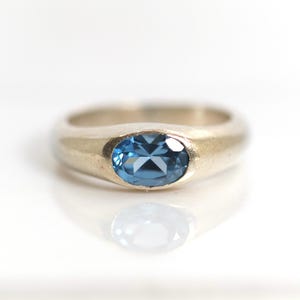 Anel em prata de lei 925, com espinélio azul solitário de corte oval, tamanho 55.