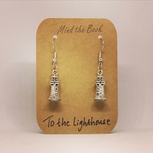 May include: Silver lighthouse earrings on a brown card with the text "Mind the Book" and "To the lighthouse".