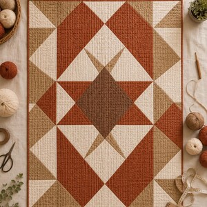 Pode incluir: Uma colcha retangular com um padr&atilde;o geom&eacute;trico de estrela em tons de laranja ferrugem, bege e creme. O tecido tem uma textura acolchoada vis&iacute;vel em forma de grade. O design &eacute; composto por tri&acirc;ngulos e uma forma de diamante central.