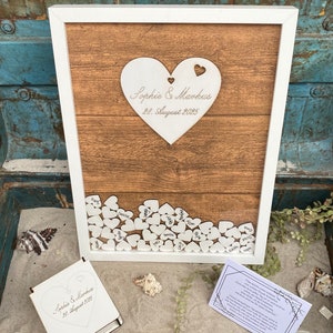 Wedding guest book as a wooden guest book frame with wooden hearts on which the guests sign