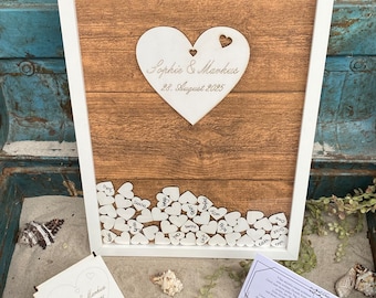 Wedding guest book as a wooden guest book frame with wooden hearts on which the guests sign