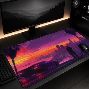 Pode incluir: Um tapete de secretária retangular com uma ilustração vibrante de um pôr do sol em tons de roxo e laranja. O design apresenta um carro desportivo, a silhueta de uma pessoa de pé, palmeiras e o horizonte de uma cidade.