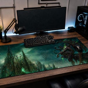 Puede incluir: Una alfombrilla de escritorio rectangular con una ilustración de fantasía oscura que muestra un imponente castillo gótico a la izquierda y una criatura alada con detalles en verde brillante a la derecha, sobre un fondo atmosférico oscuro.