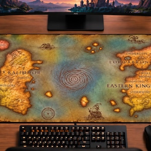 May include: A rectangular desk mat featuring a detailed fantasy map of Kalimdor and the Eastern Kingdoms. The map displays landmasses in shades of yellow and brown against a blue ocean background, with text labels for locations like Stormwind.
