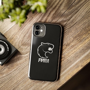 May include: A black smartphone case featuring a white graphic of a stylized panther head in profile and the text FVRIA printed in white below the animal icon. The case has a dual-camera cutout at the top left corner and a smooth, dark finish.