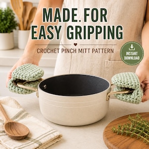 May include: A light beige cooking pot with gold-toned handles, held by two sage green crocheted pinch mitts. The text reads: MADE. FOR EASY GRIPPING, CROCHET PINCH MITT PATTERN, and INSTANT DOWNLOAD. The pot has a dark interior and a smooth exterior.