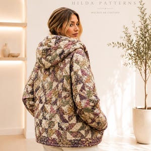 Puede incluir: Una chaqueta con capucha que presenta un diseño de patchwork acolchado con patrones triangulares en tonos apagados de verde, morado y crema. La prenda tiene mangas largas y un corte holgado, sobre pantalones claros. Texto: HP HILDA PATTERNS.