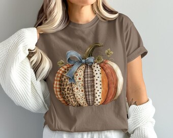 Camiseta acogedora de estilo rústico campestre con estampado de calabazas en retazos, tonos otoñales cálidos y texturas acolchadas.