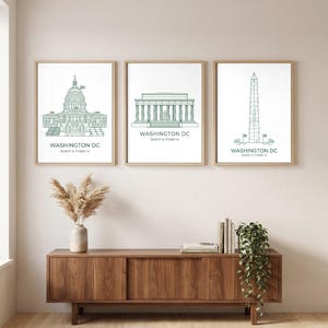 May include: Three framed wall art prints featuring green line drawings of Washington DC landmarks: the Capitol building, the Lincoln Memorial, and the Washington Monument. Each print includes the text WASHINGTON DC and geographic coordinates.