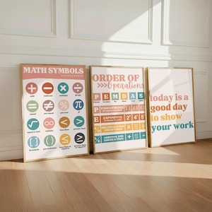 May include: Three framed educational posters with light backgrounds. The first displays MATH SYMBOLS with colourful icons. The second shows ORDER OF OPERATIONS PEMDAS with colour-coded rows. The third reads today is a good day to show your work.