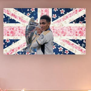 Peut inclure: Une impression murale rectangulaire représentant un portrait de footballeur en maillot blanc tenant un trophée argenté. Le fond est un motif de drapeau Union Jack stylisé superposé à un champ bleu foncé et des fleurs de cerisier roses et blanches.