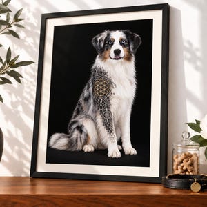 Könnte beinhalten: Ein gerahmter Kunstdruck mit dem Porträt eines Blue-Merle-Australian-Shepherd-Hundes vor schwarzem Hintergrund. Der Hund zeigt eine digitale Überlagerung eines geometrischen Gold- und Schwarzmusters der Blume des Lebens auf Schulter und Vorderbein.