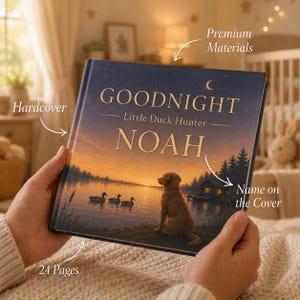 Op de afbeelding: Een hardcover boek getiteld Goodnight Little Duck Hunter NOAH met op de voorkant een zonsondergang bij een meer, een golden retriever zittend aan de oever, drie zwemmende eenden, een kleine hut en een sterrenhemel afgebeeld op de kaft.