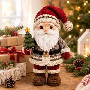 Puede incluir: Un muñeco de Papá Noel tejido a ganchillo con un gorro rojo con pompón crema, abrigo gris con cinturón negro y botas marrones. La figura tiene una barba de hilo blanco y sostiene un pequeño árbol de Navidad tejido con una estrella amarilla.